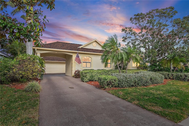 view of front of house with a garage and a lawn