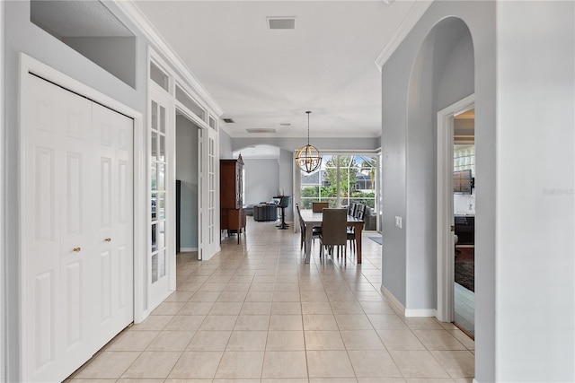 tiled dining area featuring ornamental molding and a chandelier