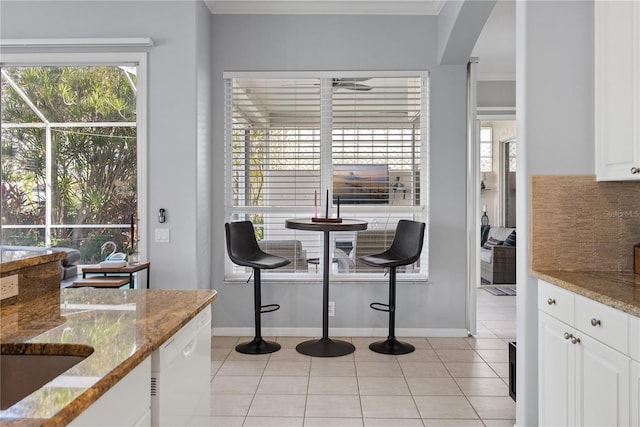 dining room with light tile patterned floors, crown molding, and sink