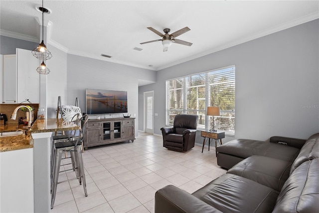 tiled living room with ceiling fan, ornamental molding, and sink