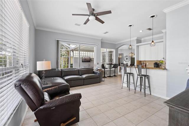 tiled living room with ceiling fan and crown molding