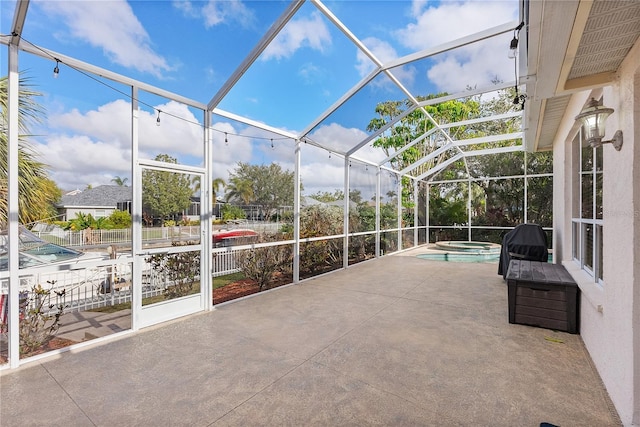 view of patio with a swimming pool with hot tub and glass enclosure