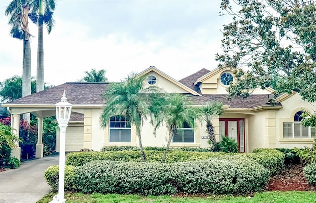 4531 Swordfish Dr, Bradenton, FL 34208 - view of front facade with stucco siding, concrete driveway, a shingled roof, and a garage