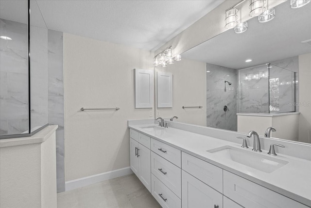 bathroom featuring vanity, a tile shower, and a textured ceiling