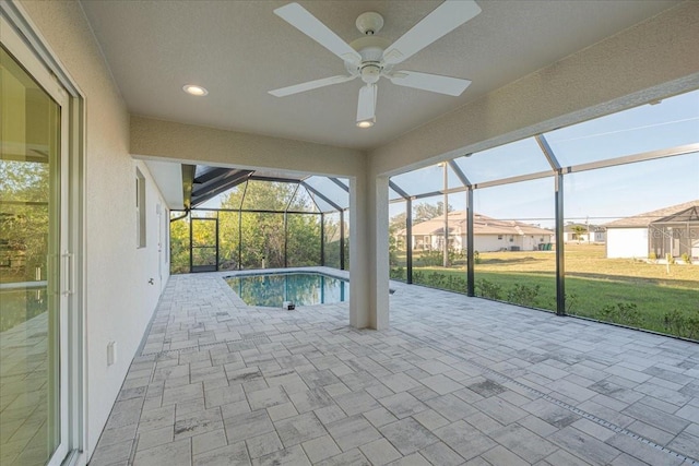 view of pool with a lawn, ceiling fan, a patio area, and a lanai