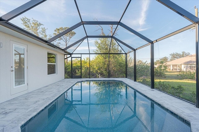 view of swimming pool with glass enclosure and a patio area