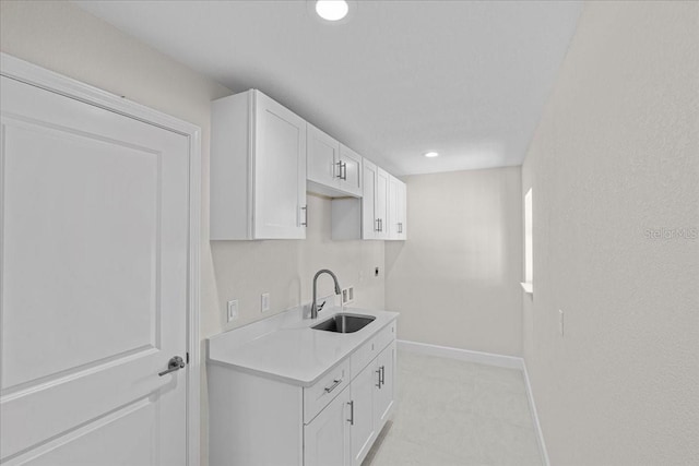 kitchen featuring white cabinetry and sink