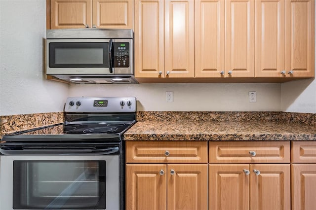 kitchen with dark stone countertops and appliances with stainless steel finishes