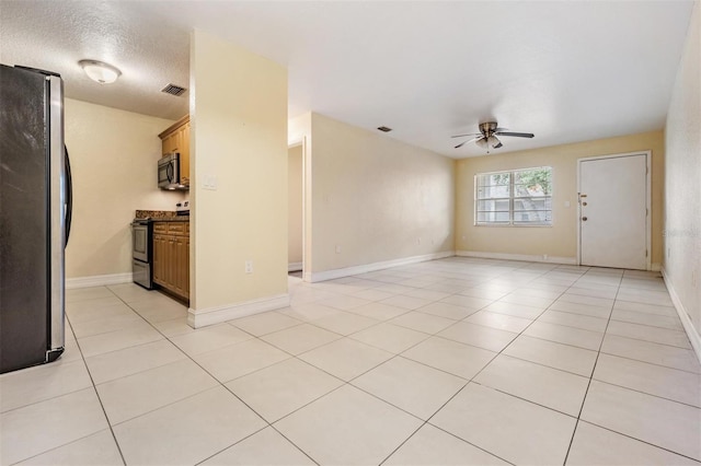 tiled spare room with ceiling fan and a textured ceiling