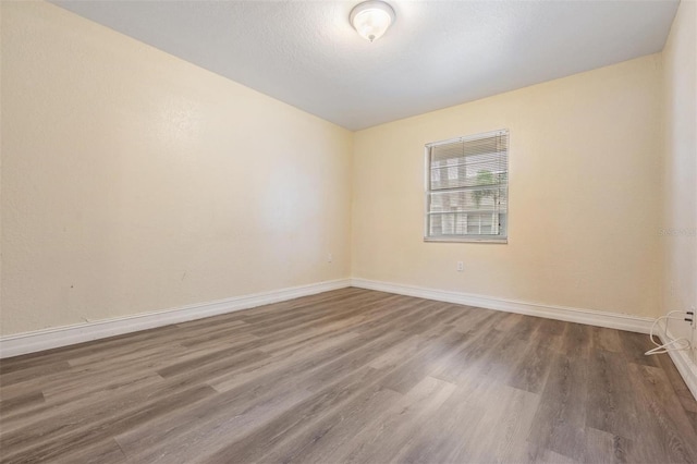 empty room with dark hardwood / wood-style floors and a textured ceiling