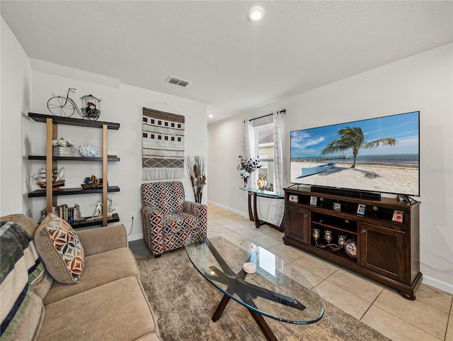 living room featuring light tile patterned flooring and a textured ceiling