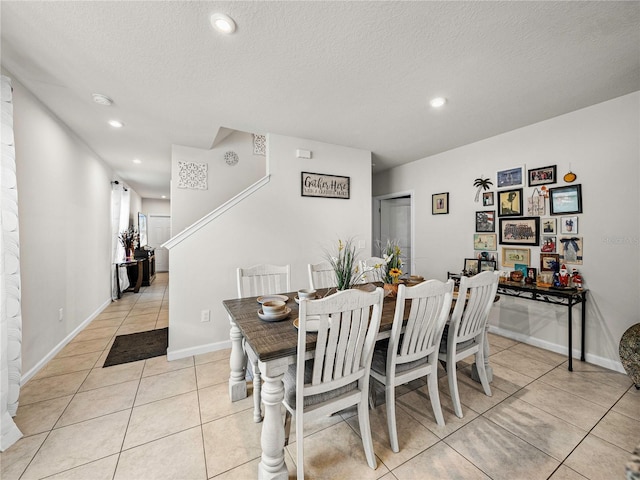 dining area with light tile patterned floors and a textured ceiling