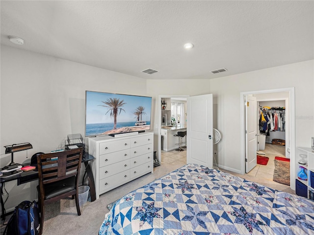 bedroom featuring a walk in closet and a textured ceiling