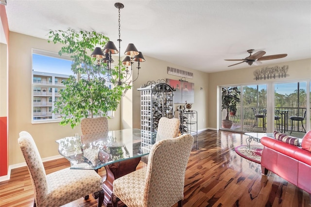 dining space with hardwood / wood-style floors and ceiling fan with notable chandelier