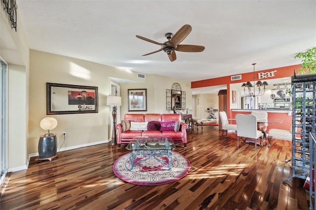 living room with hardwood / wood-style flooring and ceiling fan with notable chandelier