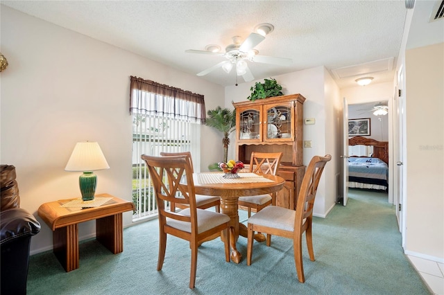 dining area with a textured ceiling and light carpet