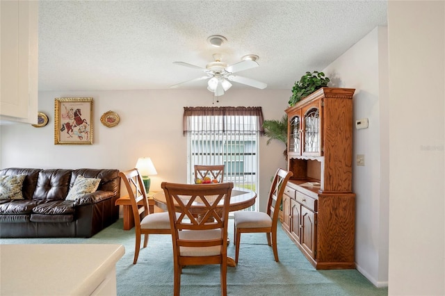 dining area with light carpet, a textured ceiling, and ceiling fan