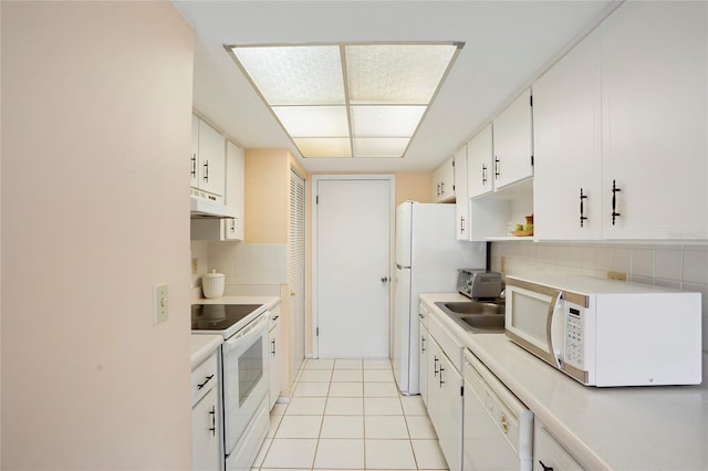 kitchen featuring white appliances, light tile patterned floors, decorative backsplash, white cabinets, and sink