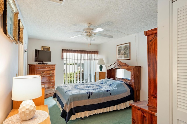 bedroom featuring ceiling fan, a textured ceiling, and dark carpet