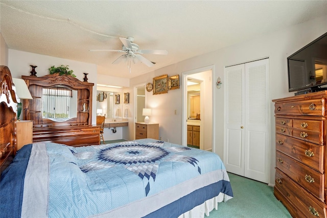 carpeted bedroom featuring ensuite bathroom, a textured ceiling, and ceiling fan