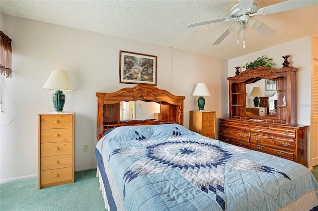 bedroom with ceiling fan, carpet floors, and a textured ceiling