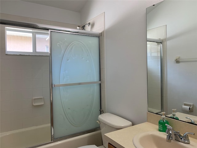 full bathroom featuring vanity, enclosed tub / shower combo, and toilet