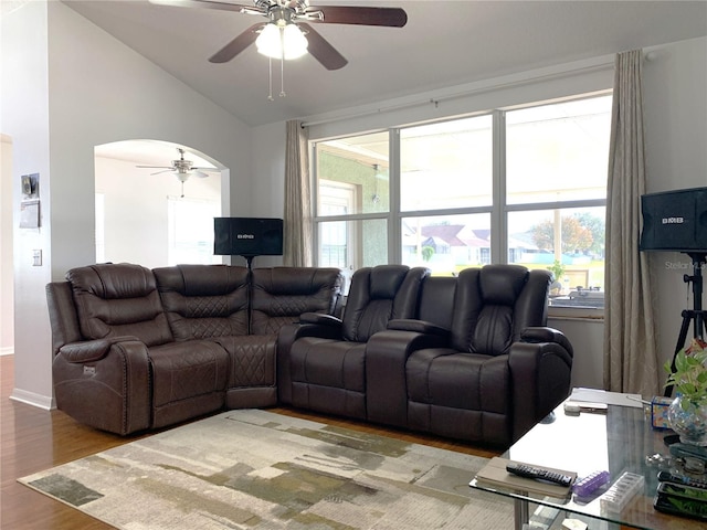 living room with wood-type flooring, vaulted ceiling, ceiling fan, and a healthy amount of sunlight