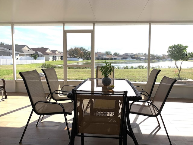 sunroom featuring a water view