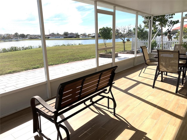 sunroom featuring plenty of natural light and a water view