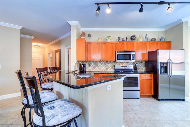 kitchen with decorative backsplash, dark stone counters, stainless steel appliances, sink, and light tile patterned floors