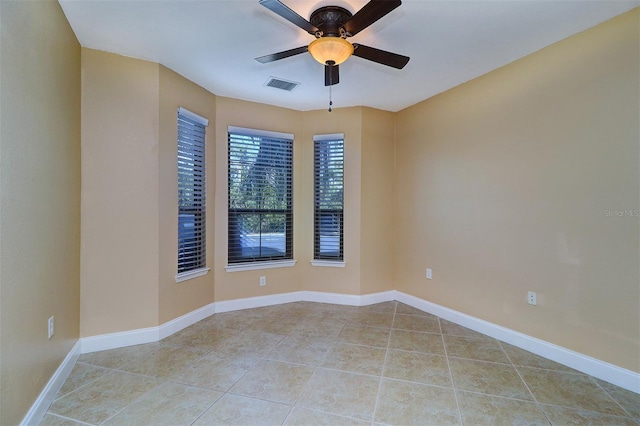 tiled empty room featuring ceiling fan