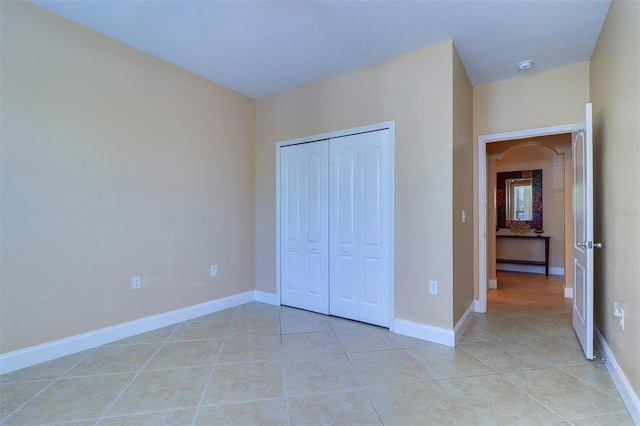 unfurnished bedroom featuring a closet and light tile patterned floors