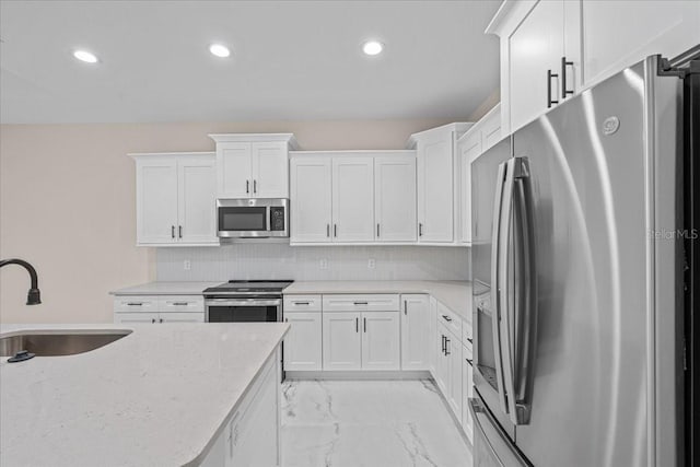 kitchen featuring decorative backsplash, sink, white cabinetry, and stainless steel appliances