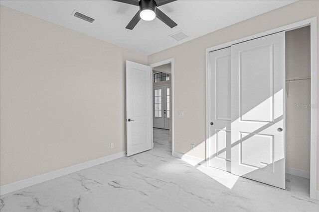 empty room featuring ceiling fan and french doors