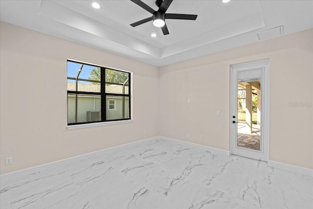 unfurnished room featuring a tray ceiling and ceiling fan