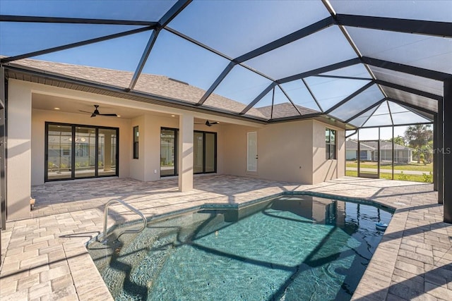 view of swimming pool with a patio, glass enclosure, and ceiling fan