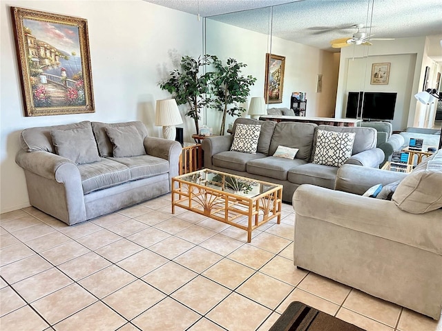 living room featuring ceiling fan, a textured ceiling, and light tile patterned flooring