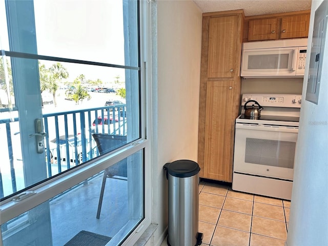 kitchen featuring light tile patterned floors and white appliances