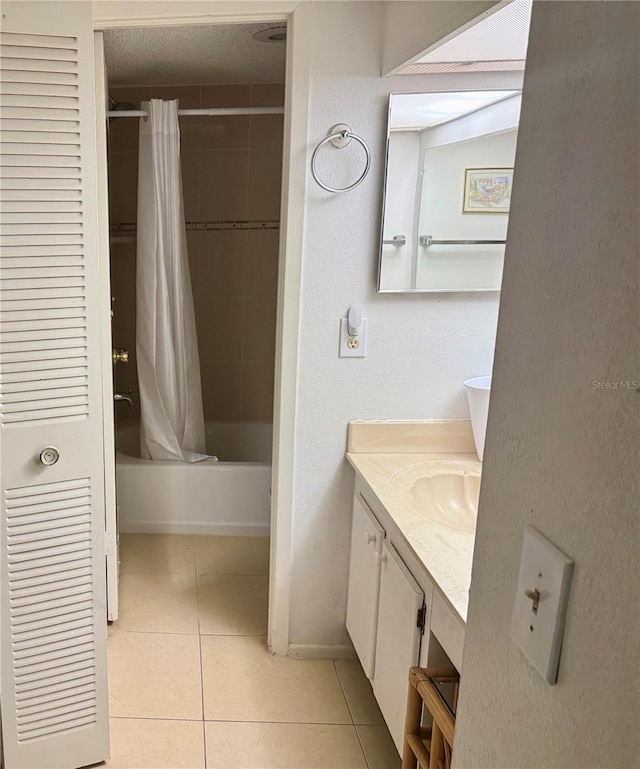 bathroom with tile patterned floors, shower / bathtub combination with curtain, and vanity