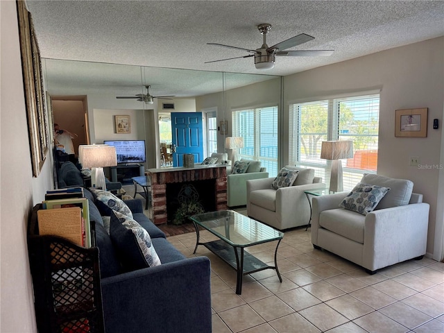living area featuring light tile patterned floors, a textured ceiling, and ceiling fan