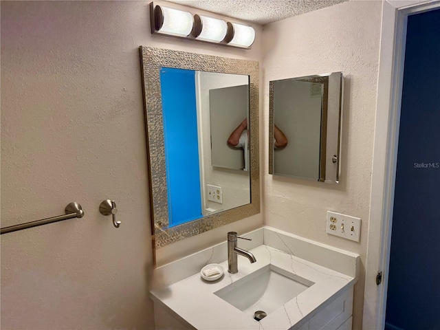 bathroom with vanity and a textured wall