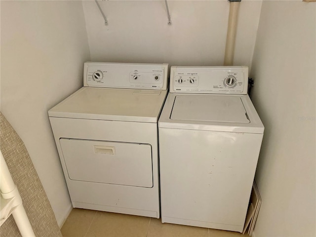 laundry room with light tile patterned floors, washing machine and dryer, and laundry area