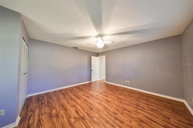 unfurnished bedroom featuring hardwood / wood-style flooring, ceiling fan, and a textured ceiling