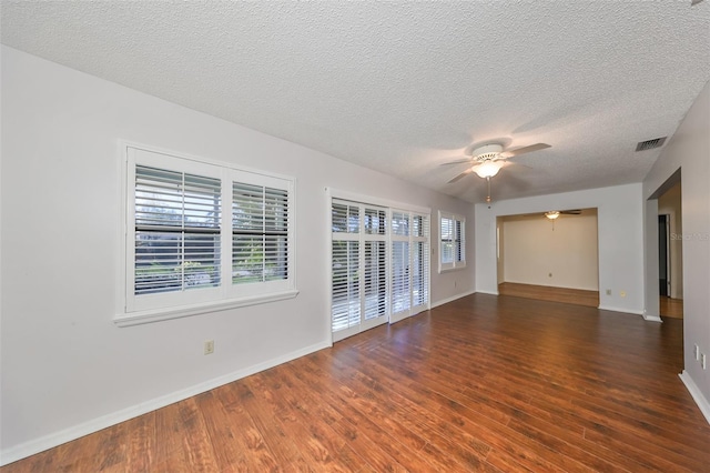 spare room featuring a textured ceiling, ceiling fan, and dark hardwood / wood-style floors