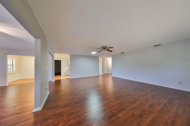 spare room featuring ceiling fan, dark wood-type flooring, and a textured ceiling