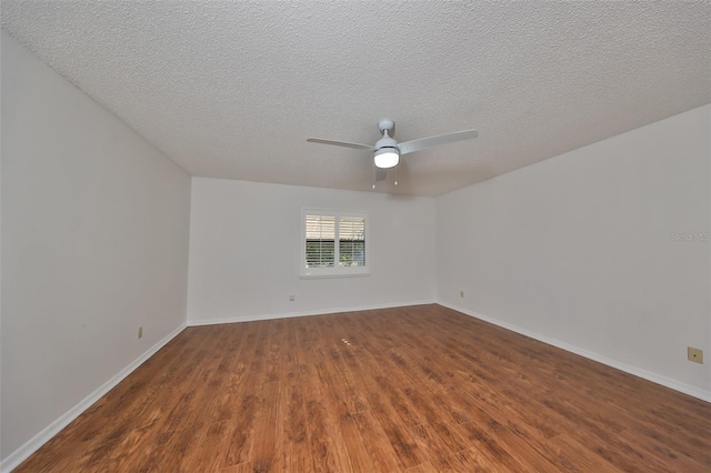 empty room featuring ceiling fan, dark wood-type flooring, and a textured ceiling