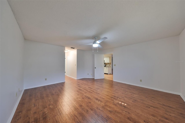 empty room featuring dark hardwood / wood-style flooring and a textured ceiling