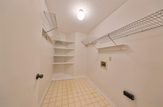 laundry room featuring hookup for a washing machine and a textured ceiling