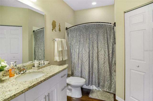 bathroom with hardwood / wood-style flooring, vanity, a shower with shower curtain, and toilet