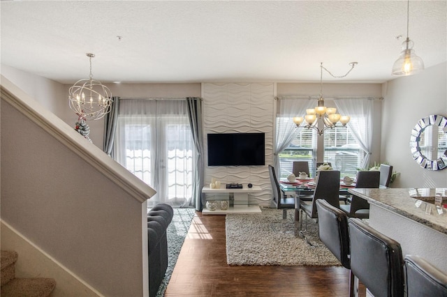 living room featuring dark hardwood / wood-style flooring, a textured ceiling, and a notable chandelier